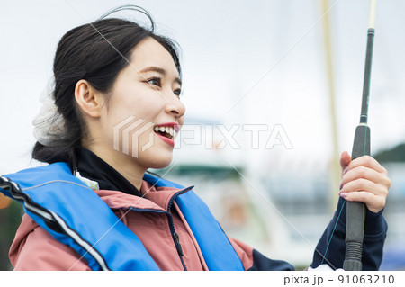 魚釣りをするかわいい女性 魚釣りをするかわいい女性 91063210