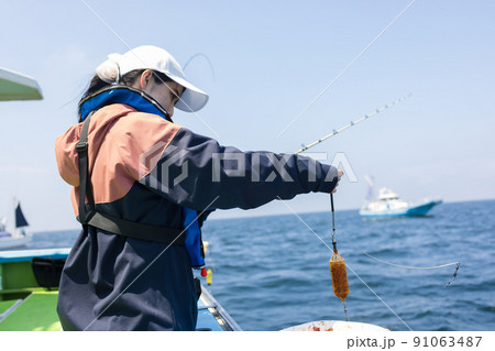 魚釣りをするかわいい女性 魚釣りをするかわいい女性 91063487