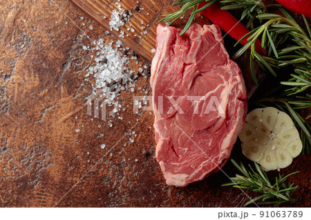 Raw beef meat steak with rosemary, garlic, salt, and pepper. Raw beef meat steak with rosemary, garlic, salt, and pepper. 91063789