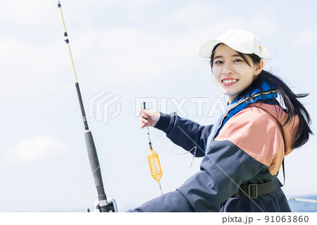 魚釣りを楽しむかわいい女性 魚釣りを楽しむかわいい女性 91063860