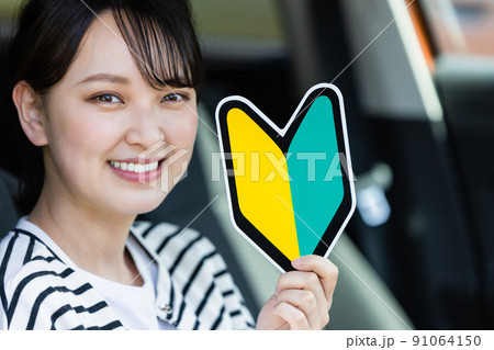初心者マークを持った若い女性ドライバー 91064150