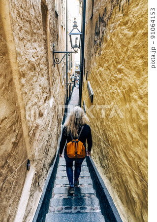 Woman in the narrowest street of Stockholm Woman in the narrowest street of Stockholm 91064153