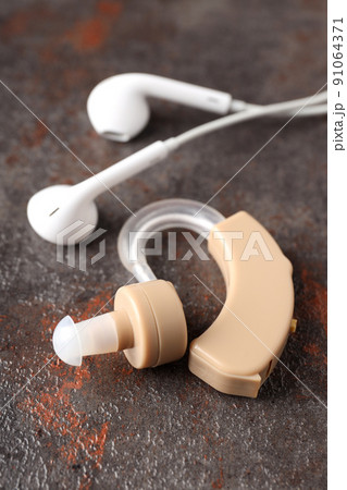 Concept of health care with hearing aid on dark textured background Concept of health care with hearing aid on dark textured background 91064371