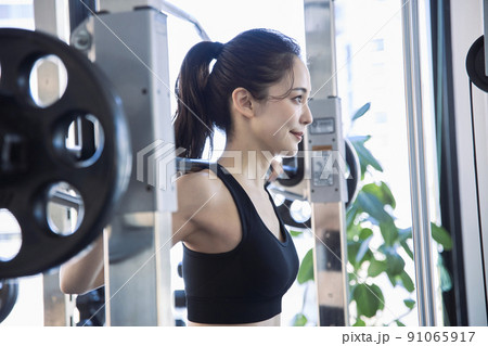 スポーツジムでトレーニングをする若い女性 スポーツジムでトレーニングをする若い女性 91065917