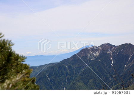 〔山梨県・6月〕鳳凰三山と富士山　甲斐駒ヶ岳・黒戸尾根コース8合目の鎖場から 91067685