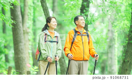 新緑の山歩きをするシニア夫婦 91068731