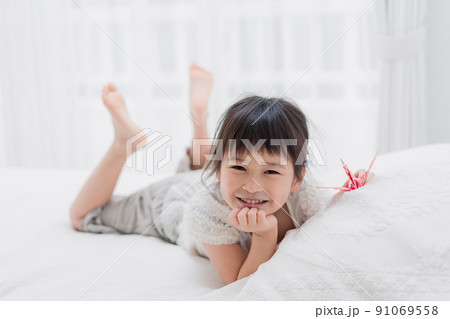 ベッドに寝転がる小さな女の子 ベッドに寝転がる小さな女の子 91069558