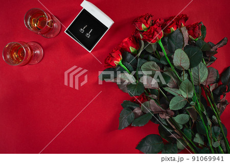 Jewelry set of golden earrings in a gift box and red roses on re Jewelry set of golden earrings in a gift box and red roses on re 91069941