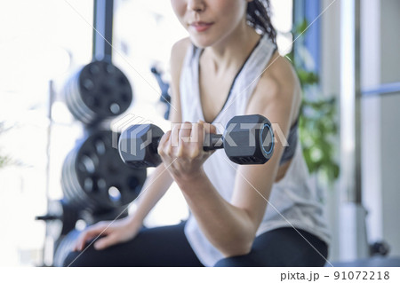 スポーツジムでトレーニングをする若い女性 スポーツジムでトレーニングをする若い女性 91072218