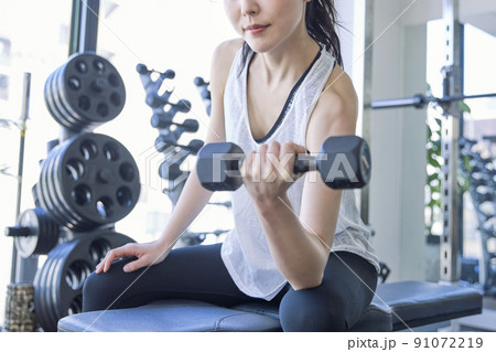スポーツジムでトレーニングをする若い女性 スポーツジムでトレーニングをする若い女性 91072219