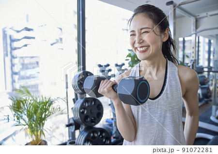 スポーツジムでトレーニングをする若い女性 91072281