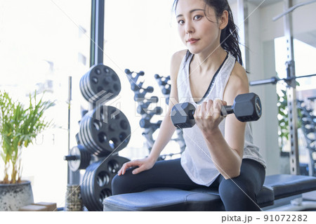 スポーツジムでトレーニングをする若い女性 91072282