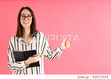 Young attractive woman in glasses on pink background Young attractive woman in glasses on pink background 91072434