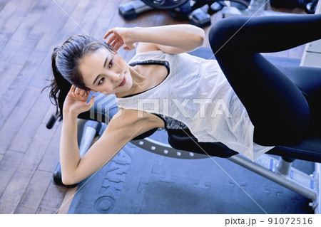 スポーツジムでトレーニングをする若い女性 91072516
