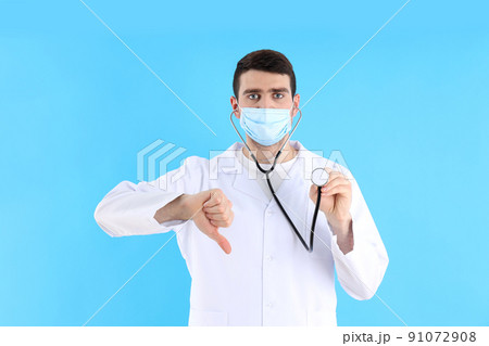 Young man doctor with stethoscope on blue background Young man doctor with stethoscope on blue background 91072908