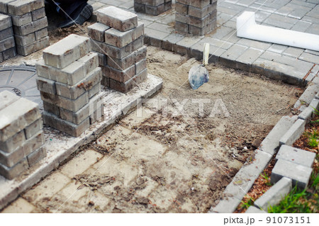 View of new paving slabs and concrete blocks on summer day at construction site. Stone blocks stand View of new paving slabs and concrete blocks on summer day at construction site. Stone blocks stand 91073151