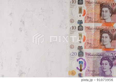 Pounds sterling. Cash UK. The latest design of the 10 and 20 pound notes with plastic inserts. On a gray textured background Pounds sterling. Cash UK. The latest design of the 10 and 20 pound notes with plastic inserts. On a gray textured background 91073956