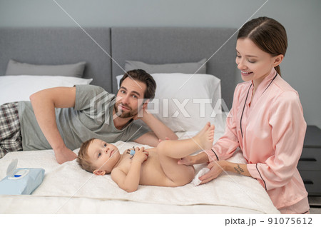 Woman touching baby man looking at camera 91075612