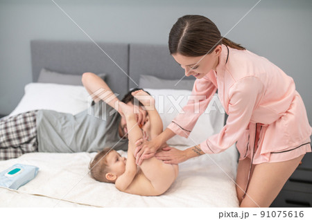 Woman sideways to camera touching babys skin 91075616