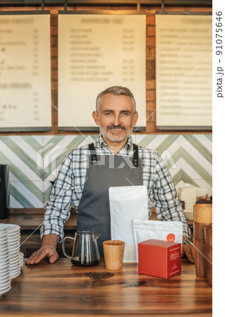 Man confidently looking at camera standing behind bar 91075646