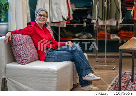 Smiling woman resolutely looking at camera sitting in atelier 91075658