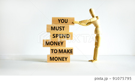 Spend and make money symbol. Wood blocks with words You must spend money to make money. Beautiful white table white background Businessman model. Business spend and make money concept. Copy space. Spend and make money symbol. Wood blocks with words You must spend money to make money. Beautiful white table white background Businessman model. Business spend and make money concept. Copy space. 91075795
