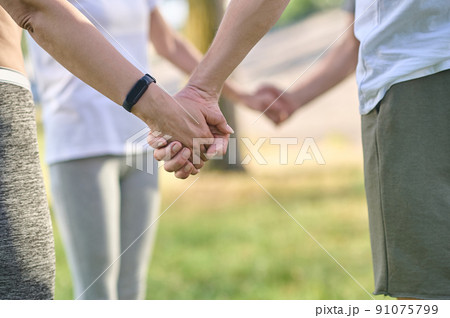 Close up picture of peples hands holding each other Close up picture of peples hands holding each other 91075799