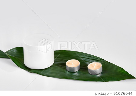 Skin care beauty treatment with jar of body moisturizer. White body lotion with big green leaf on light background. Skin care beauty treatment with jar of body moisturizer. White body lotion with big green leaf on light background. 91076044