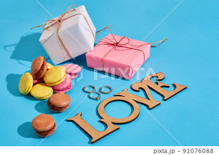 Macaroons and gift boxes on a blue background with the words I l 91076088
