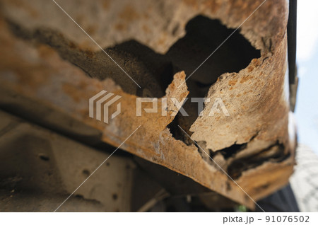 Rusty car body damaged by corrosion with hole on threshold 91076502