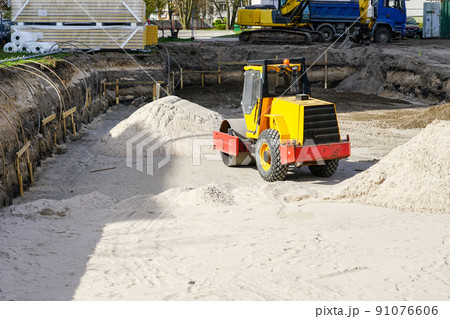 Construction pit of a new building with a compaction roller, sand piles and dewatering system pipes Construction pit of a new building with a compaction roller, sand piles and dewatering system pipes 91076606
