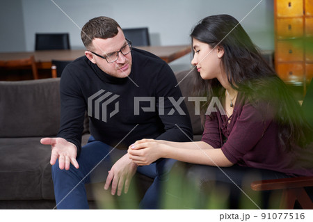 Smiling young woman visiting male therapist for session Smiling young woman visiting male therapist for session 91077516