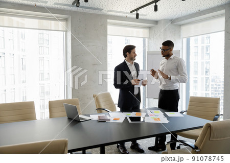 Two successful businessmen solve business in skyscraper office Two successful businessmen solve business in skyscraper office 91078745