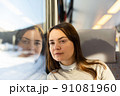 Contemplative woman looking out window while travelling by train 91081960