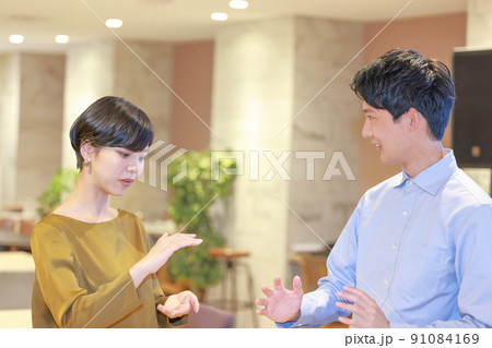 3594_両手で高さ大きさを表現しながら打ち合わせる2人のビジネスパーソン1 3594_両手で高さ大きさを表現しながら打ち合わせる2人のビジネスパーソン1 91084169
