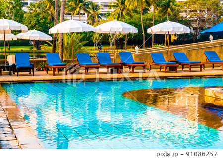 Beautiful umbrella and chair around swimming pool in hotel and resort 91086257
