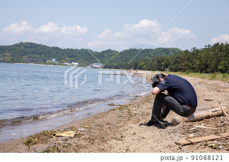 浜辺で頭を抱える男性　beach	 91088121