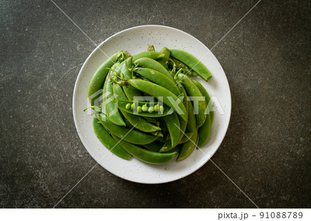 fresh sweet green peas on plate 91088789