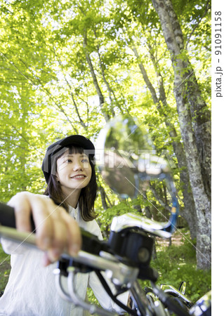 バイク女子イメージ　森でバイクにまたがる若い女性 91091158