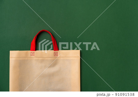 Textile shopping bag on green background flat lay 91091538
