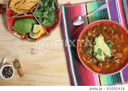 Fresh Bowl of Tortilla Soup on Wooden Table With Avocado and Cilantro 91092416