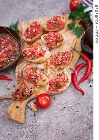 tasty salsa bruschetta snacks at domestic kitchen on wooden cutting board tasty salsa bruschetta snacks at domestic kitchen on wooden cutting board 91093029