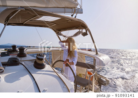 beautiful woman standing on yacht captain's bridge at sunny summer day 91093141