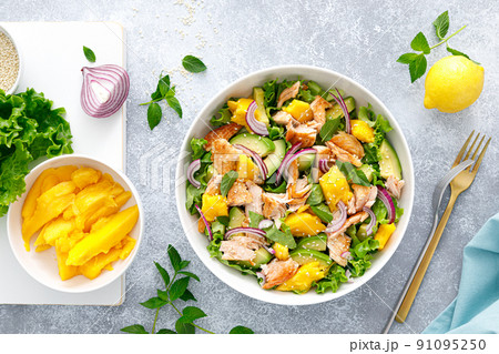 Grilled salmon and mango salad with avocado and fresh green lettuce 91095250