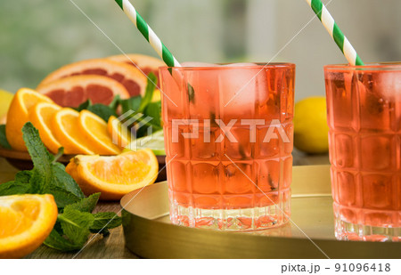 Two glasses of summer lemonade cocktail on tray, mint, fresh fruits Two glasses of summer lemonade cocktail on tray, mint, fresh fruits 91096418