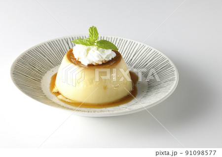平らなお皿にに盛り付けてある生クリーム、ミントの葉が乗った昔ながらのレトロプリンを白背景で撮影 平らなお皿にに盛り付けてある生クリーム、ミントの葉が乗った昔ながらのレトロプリンを白背景で撮影 91098577