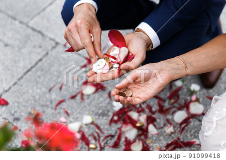 Petals and sweets in the hands of the bride and groom 91099418