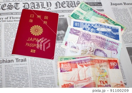 英字新聞の上に置いたシンガポールドル紙幣と日本国パスポート 英字新聞の上に置いたシンガポールドル紙幣と日本国パスポート 91100209