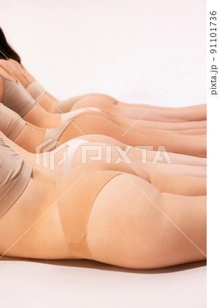 Image of slender, smooth female buttocks in beige underwear isolated over grey studio background. Anti-cellulite treatment 91101736