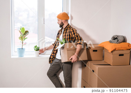Mature man unpacking things from boxes while moving in new apartment. Mature man unpacking things from boxes while moving in new apartment. 91104475